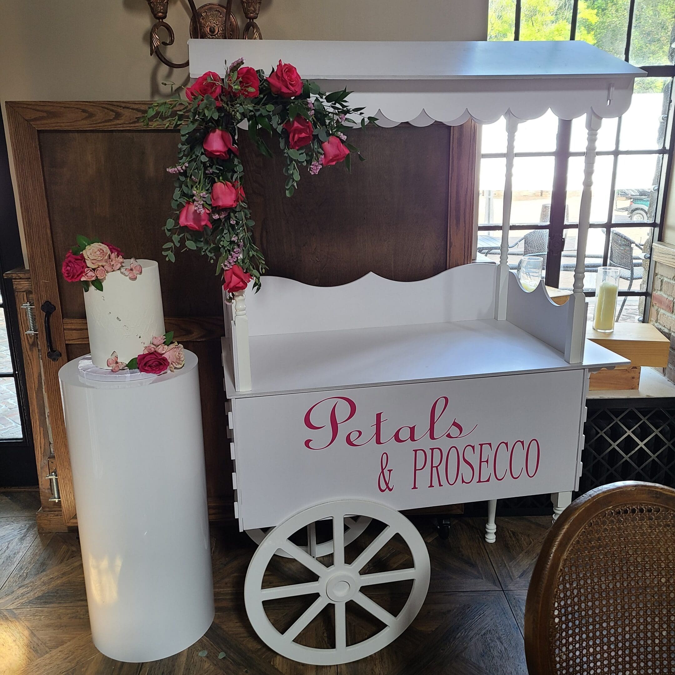 White cart decorated with flowers and candles for a special event.