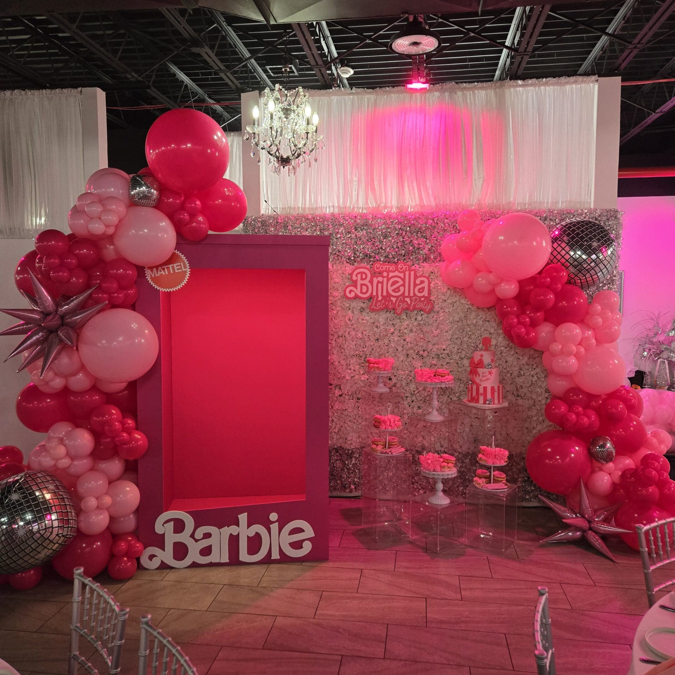 Pink-themed Barbie party setup with balloons and decorations.