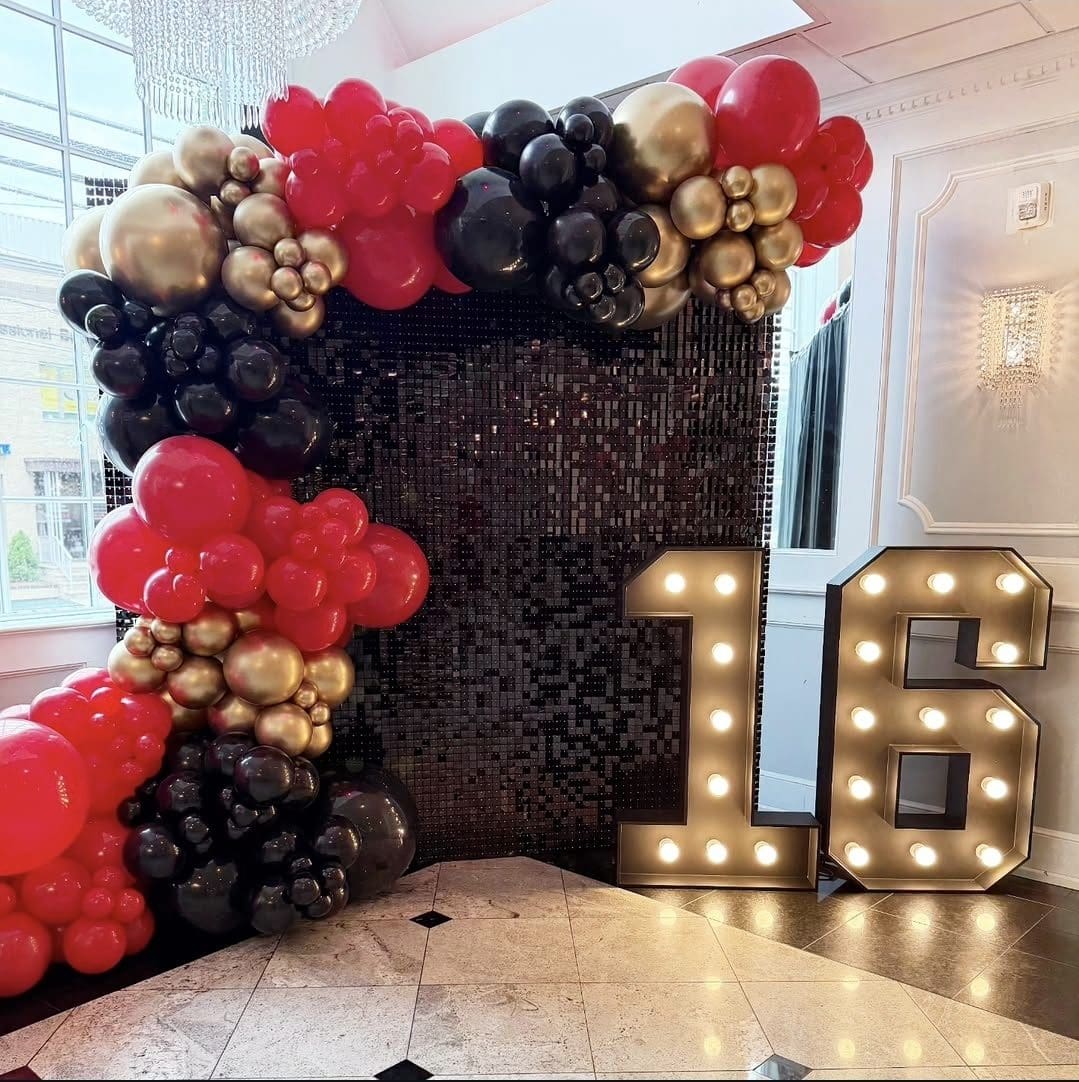 Decorative balloon arch and illuminated number 16 for a birthday celebration.