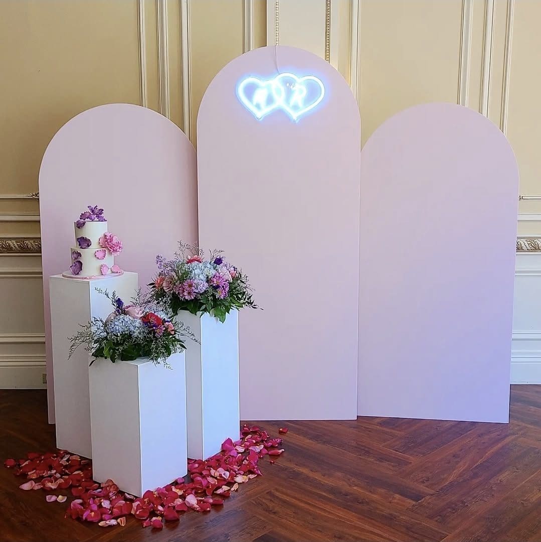 Elegant wedding backdrop with flowers and rose petals on the floor.
